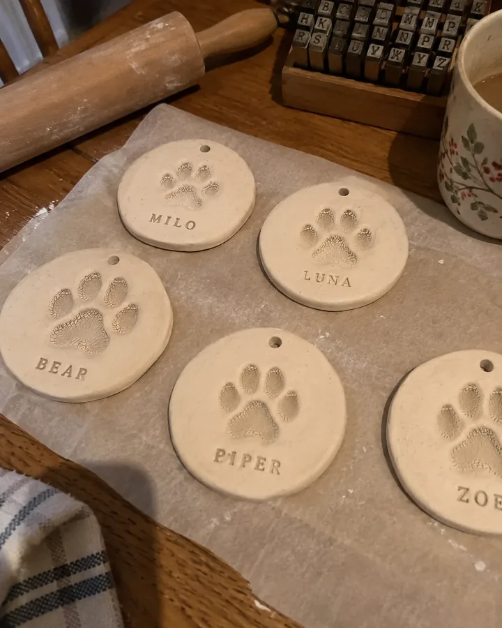 Clay paw print ornaments with pet names drying on a kitchen table